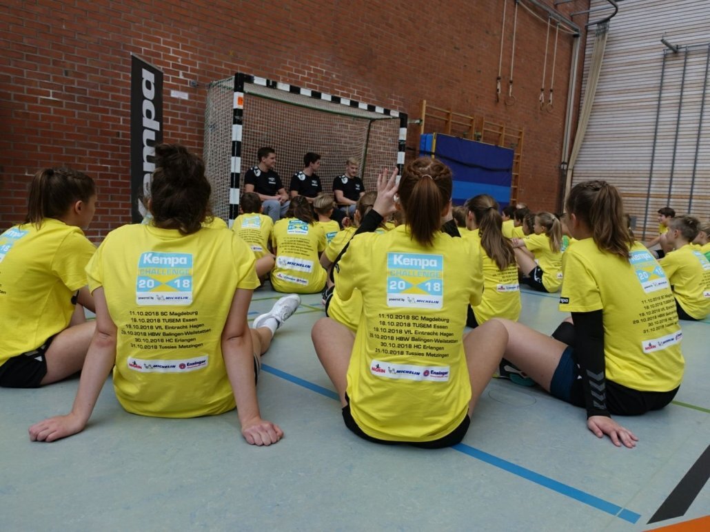 Kinder hören Handballprofis zu